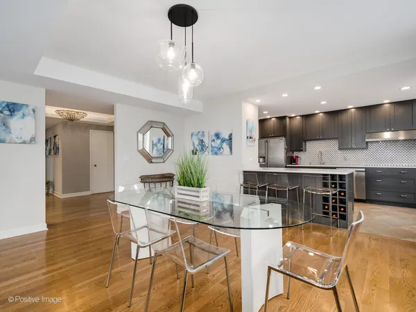 a kitchen with stainless steel appliances kitchen island granite countertop a table and chairs in it
