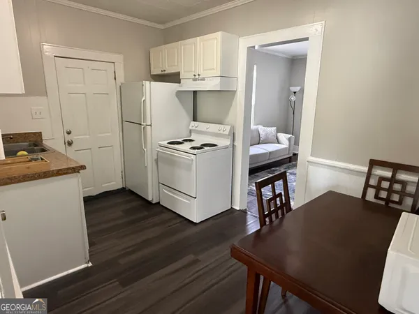 a kitchen with a table chairs refrigerator and cabinets