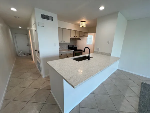 a kitchen with a sink a refrigerator and cabinets
