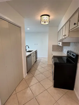 a kitchen with granite countertop a refrigerator and a sink
