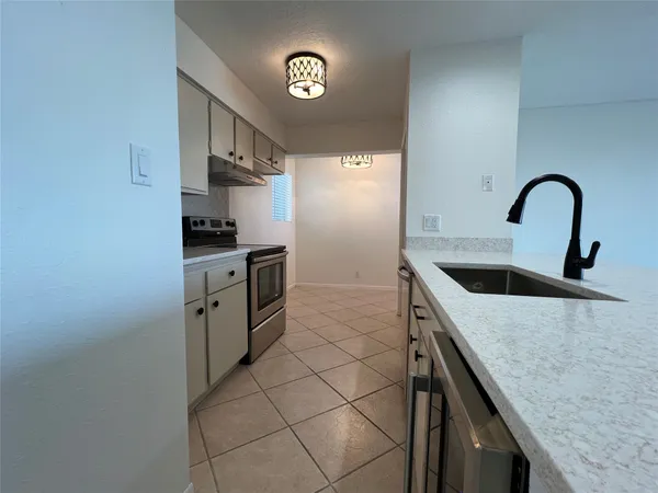 a kitchen with stainless steel appliances granite countertop a sink a stove and a refrigerator