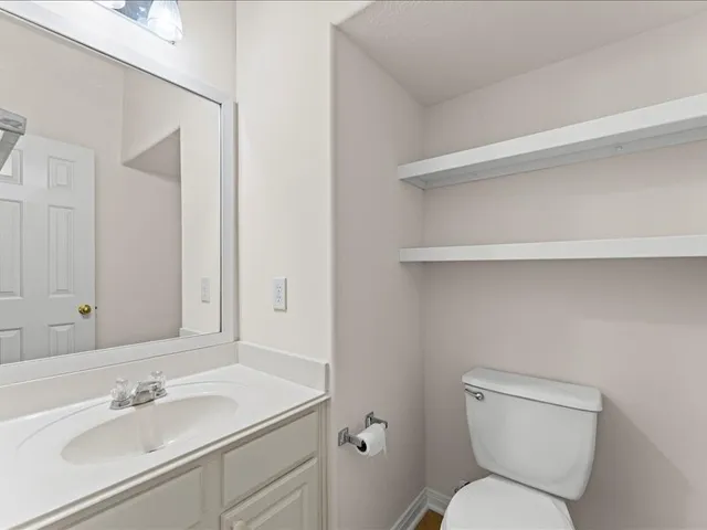 a bathroom with a toilet sink and mirror