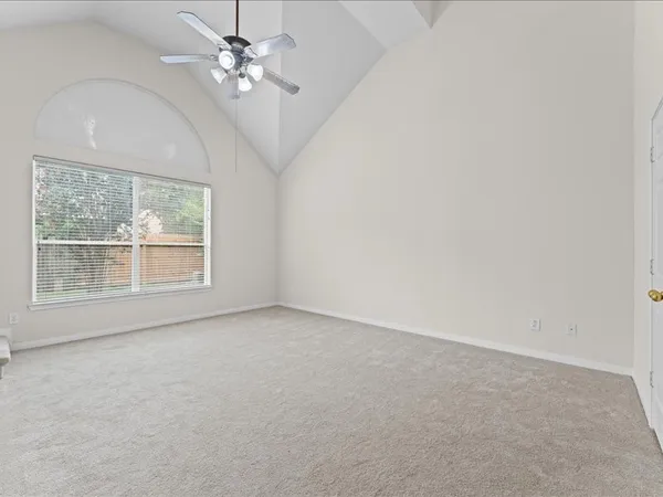 en empty room with windows and ceiling fan