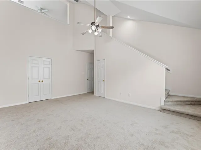 an empty room with a chandelier fan