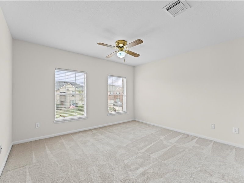 3323 Sainte Mere Eglise Lane Spring, TX 77388 - Photo 26 of 33 an empty room with chandelier fan and windows