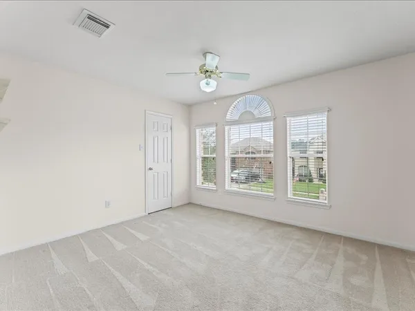 an empty room with windows ceiling fan and windows