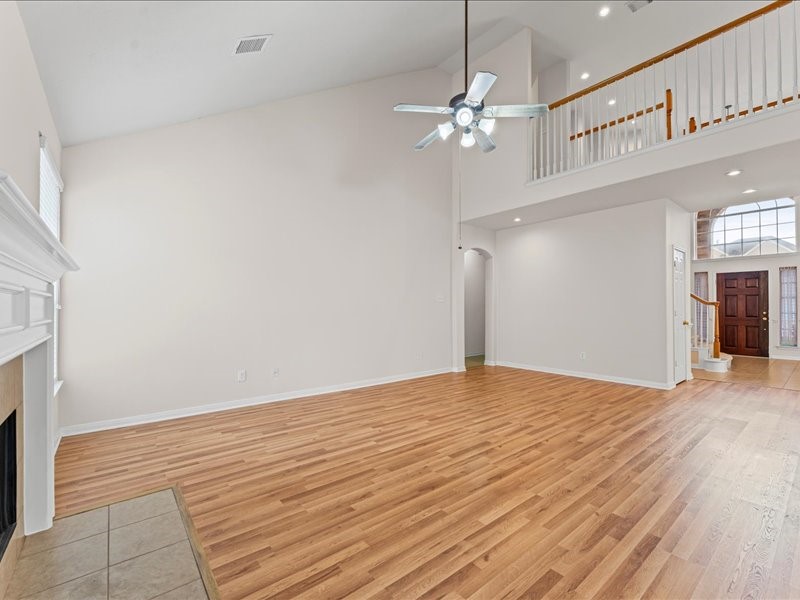 3323 Sainte Mere Eglise Lane Spring, TX 77388 - Photo 9 of 33 a view of an empty room with wooden floor and a fireplace