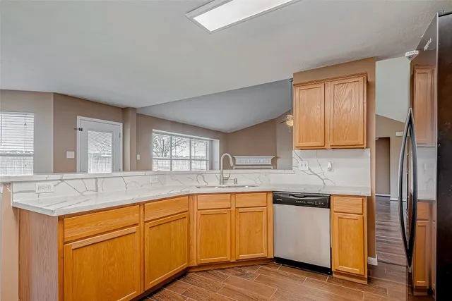 a kitchen with stainless steel appliances granite countertop a sink and cabinets with wooden floor