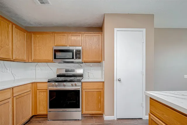 a kitchen with granite countertop white cabinets and stainless steel appliances
