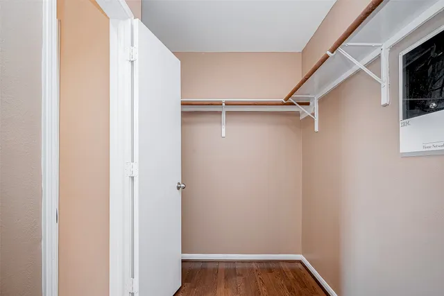 a view of walk in closet with wooden floor