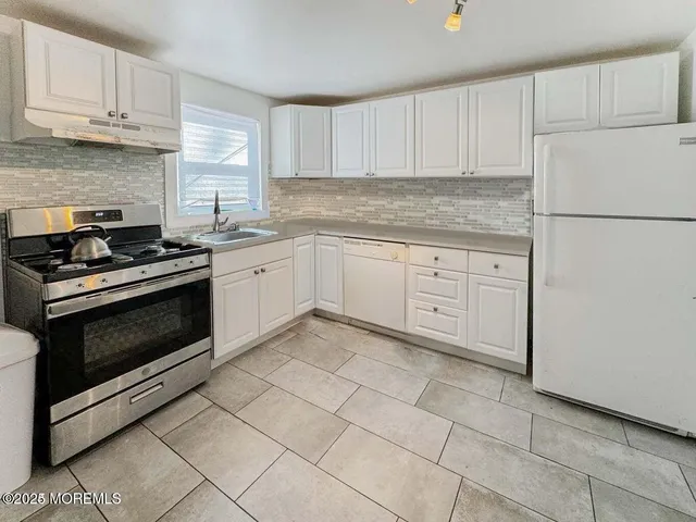 a kitchen with cabinets appliances and a sink
