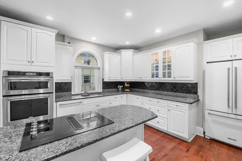 a kitchen with granite countertop stainless steel appliances and wooden cabinets