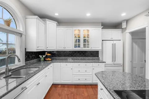 a kitchen with granite countertop a sink stainless steel appliances and cabinets