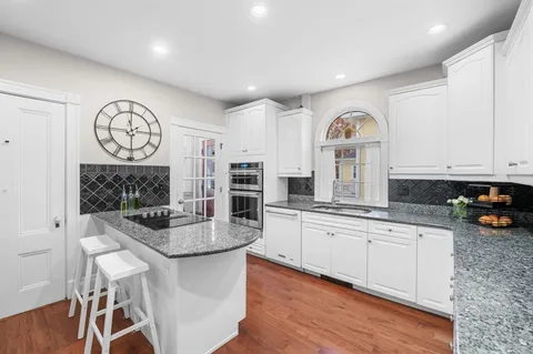 a kitchen with stainless steel appliances granite countertop a stove a sink and a refrigerator