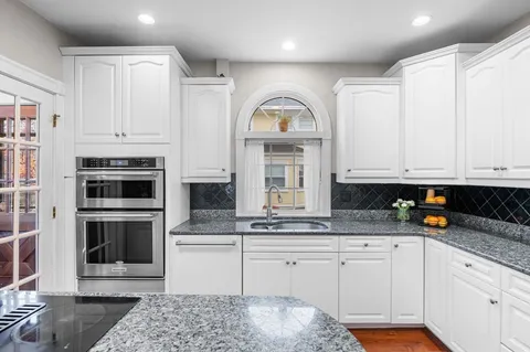 a kitchen with stainless steel appliances granite countertop a stove a sink and a microwave