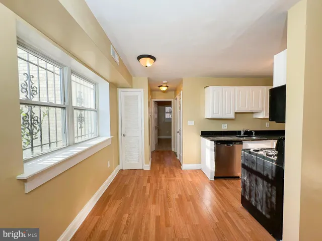 a view of a kitchen with wooden floor and electronic appliances