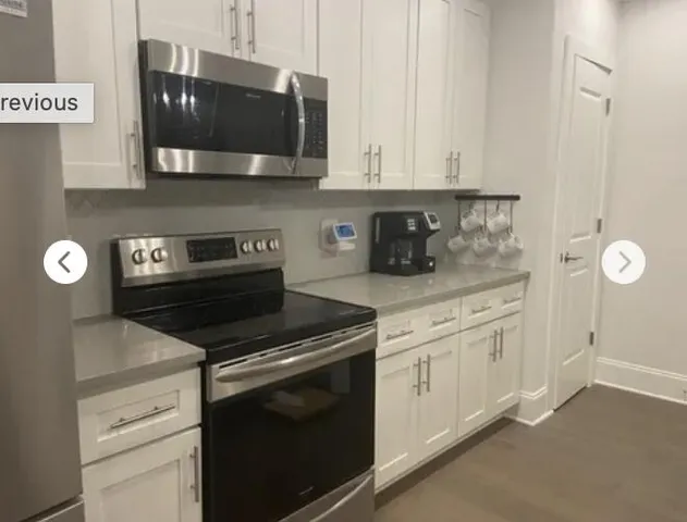a kitchen with stainless steel appliances white cabinets and a stove