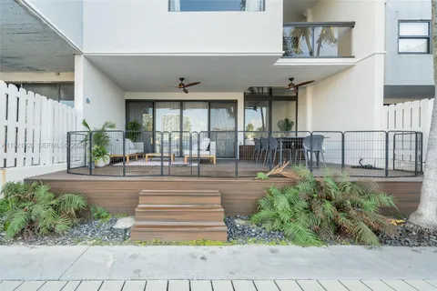 a view of a porch with chairs and potted plants