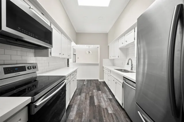 a kitchen with granite countertop a stove sink and microwave