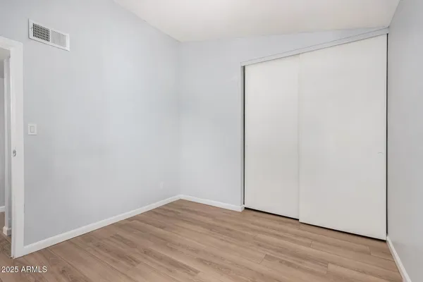 a view of an empty room with wooden floor