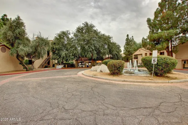 a view of a house with a tree and wooden fence