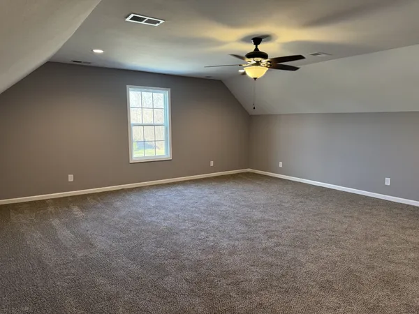 a view of a livingroom with a ceiling fan and window
