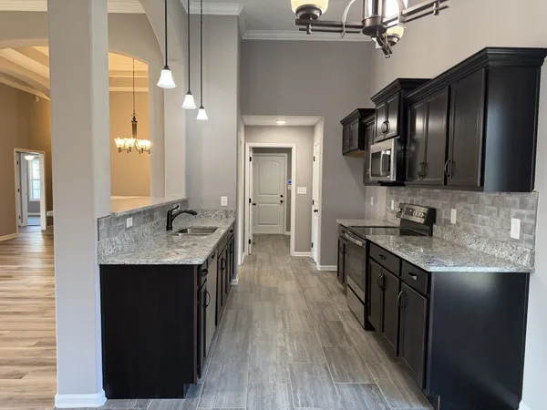 a kitchen with granite countertop stainless steel appliances cabinets a sink and a counter top space