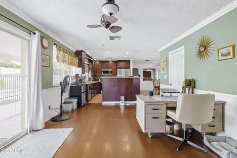 a living room with stainless steel appliances kitchen island granite countertop furniture a rug kitchen view and a large window