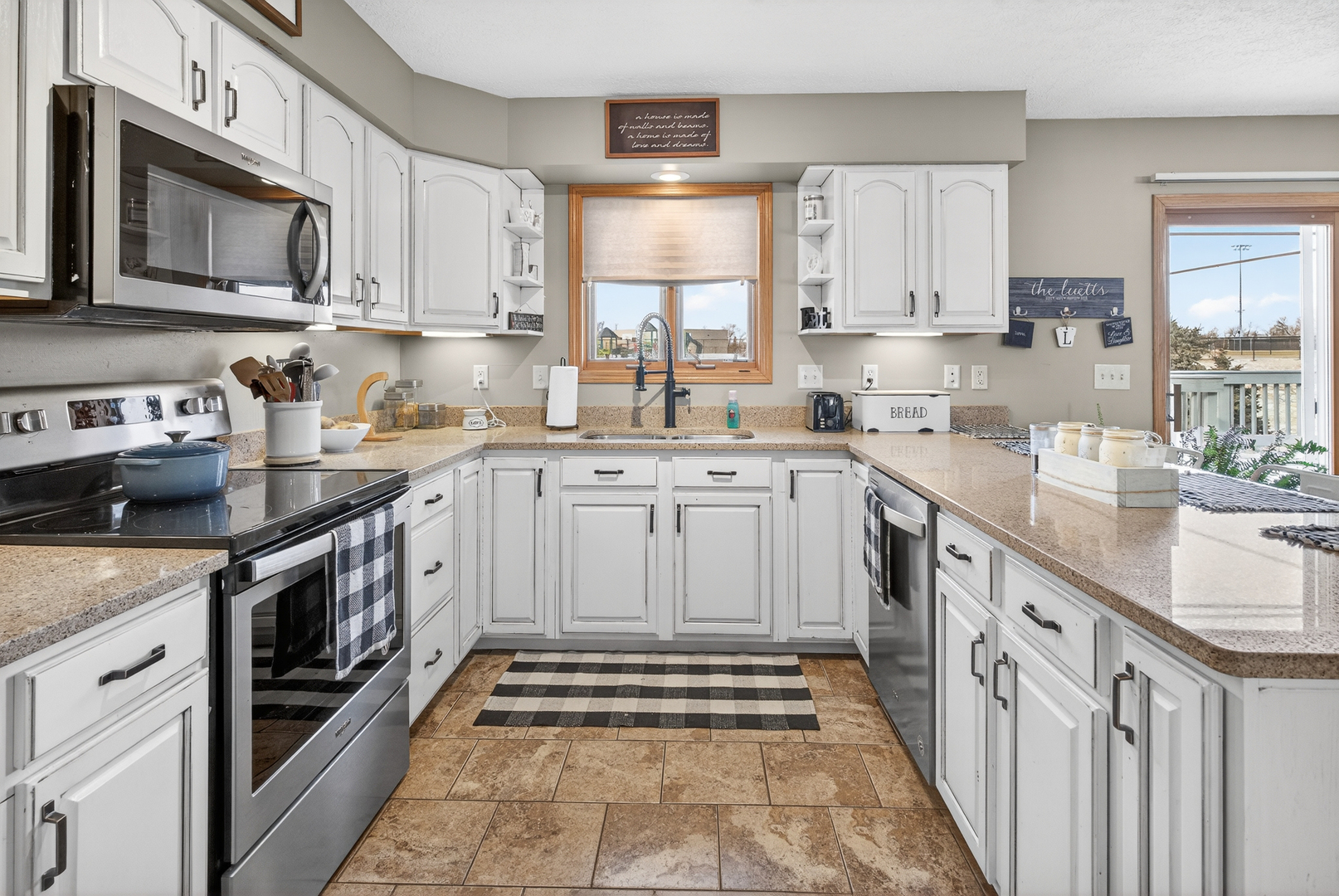 2712 North 13th Street Clinton, IA 52732 - Photo 16 of 47 a kitchen with stainless steel appliances granite countertop a sink stove a microwave and cabinets