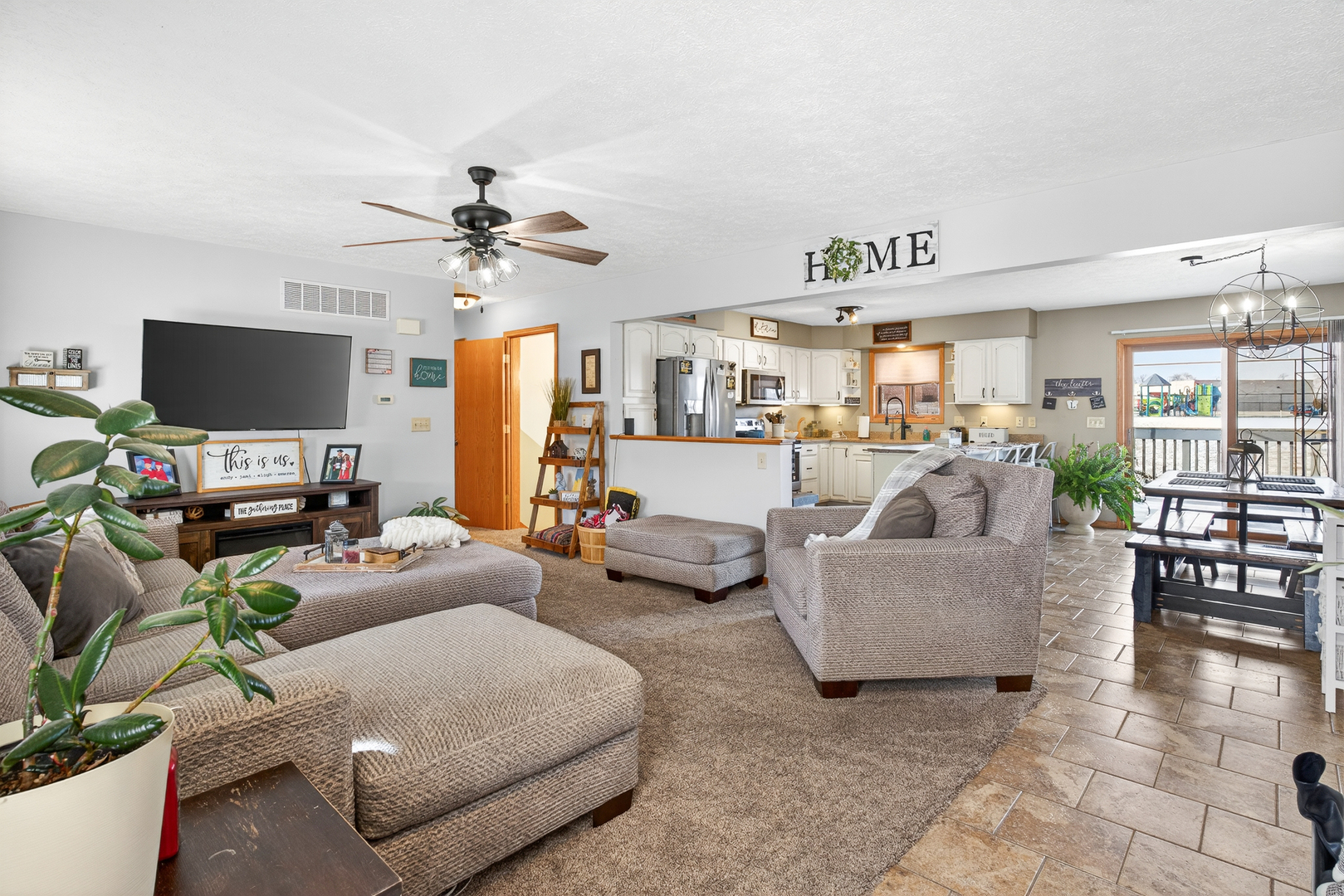 2712 North 13th Street Clinton, IA 52732 - Photo 10 of 47 a living room with furniture a flat screen tv and kitchen view
