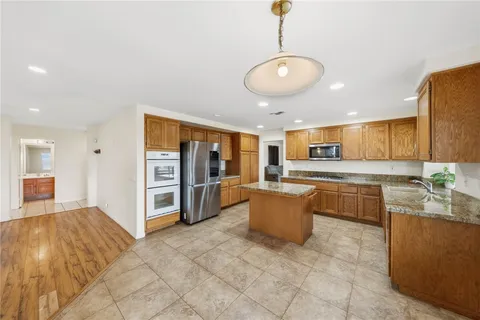a bathroom with a granite countertop sink toilet a large mirror a bathtub and window