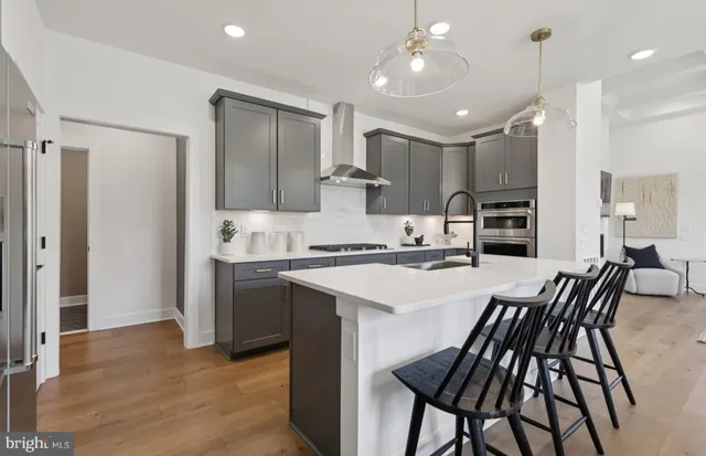 a kitchen with stainless steel appliances kitchen island granite countertop a sink and a refrigerator