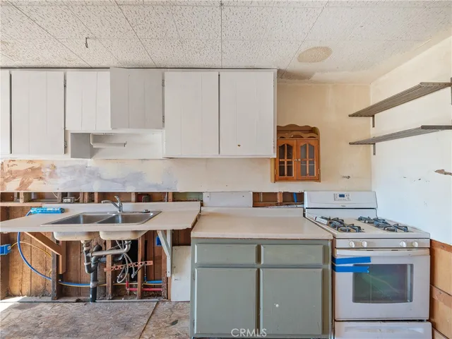 a utility room with stainless steel appliances granite countertop a stove and a refrigerator