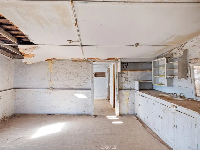 a view of a kitchen with refrigerator and cabinets