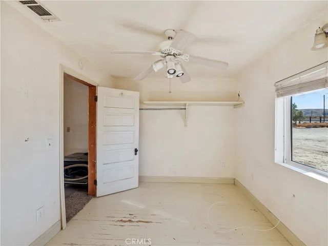 an empty room with closet and windows