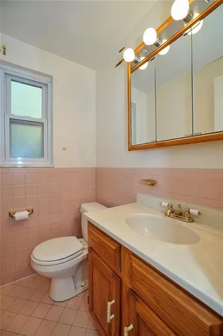 a bathroom with a sink a toilet and mirror