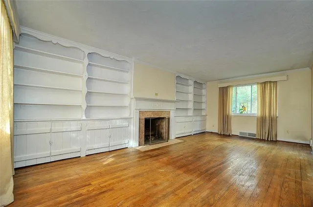 a view of an empty room with a fireplace and a window