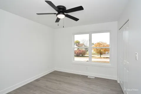 an empty room with a window and a fan
