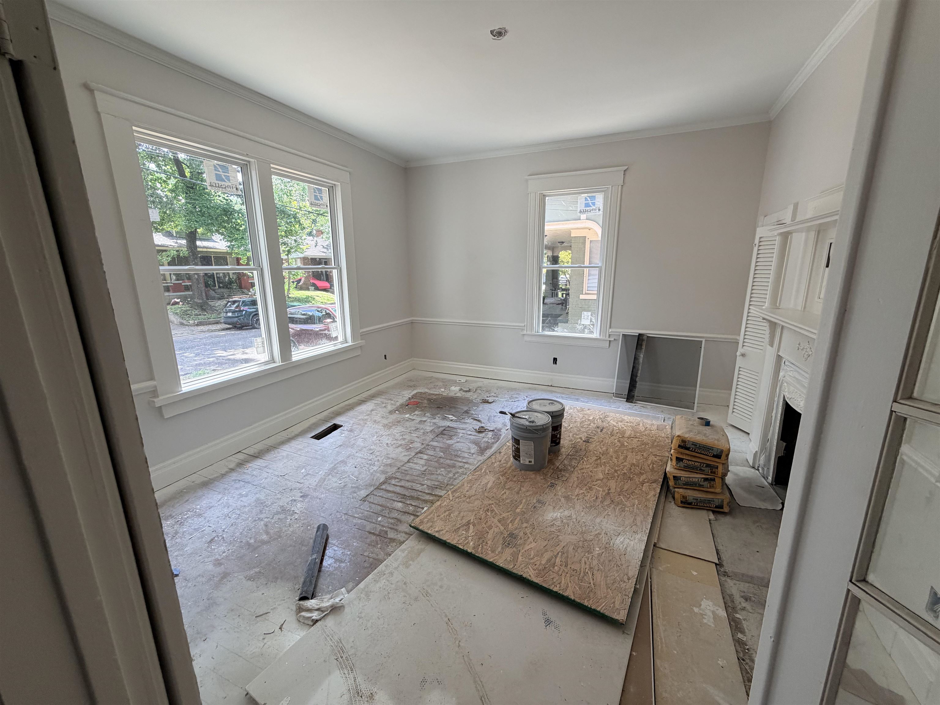 961 Meda Street Memphis, TN 38104 - Photo 6 of 27 Interior space featuring multiple windows with broad casings, crown molding, chair rail detailing, and a decorative mantelpiece