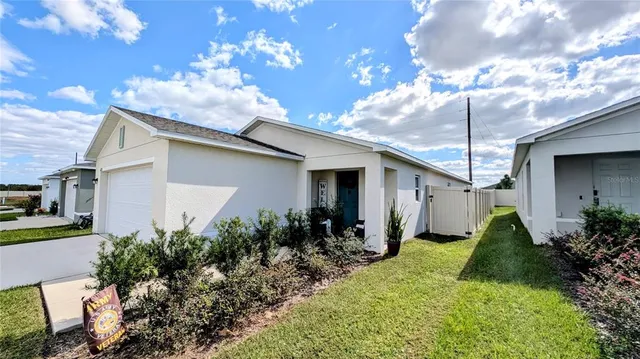 a front view of house with yard and trees in the background