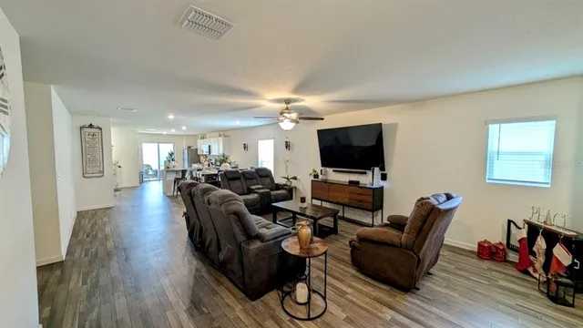 a living room with furniture flat screen tv and wooden floor