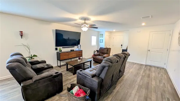 a living room with furniture a flat screen tv and a couch