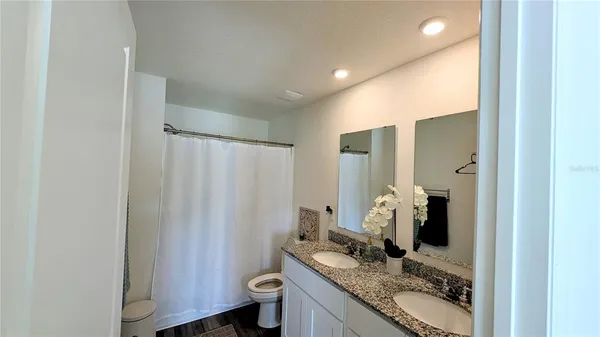 a bathroom with a granite countertop sink and a mirror