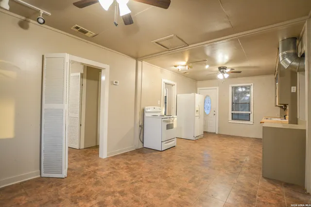 an empty room with chandelier fan