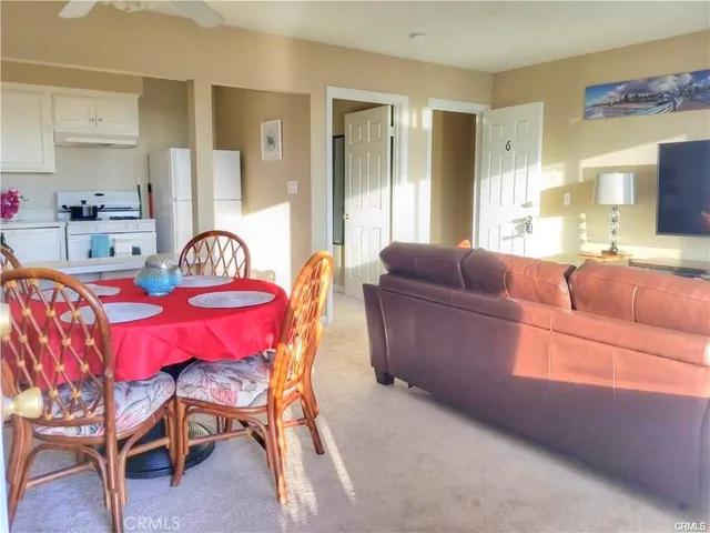 a living room with furniture a flat screen tv and a dining table
