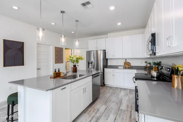 a kitchen that has a lot of cabinets a sink and appliances in it