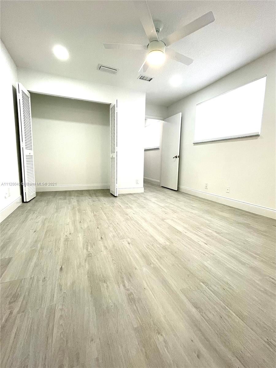 6726 Via Regina Boca Raton, FL 33433 - Photo 17 of 35 an empty room with wooden floor and windows