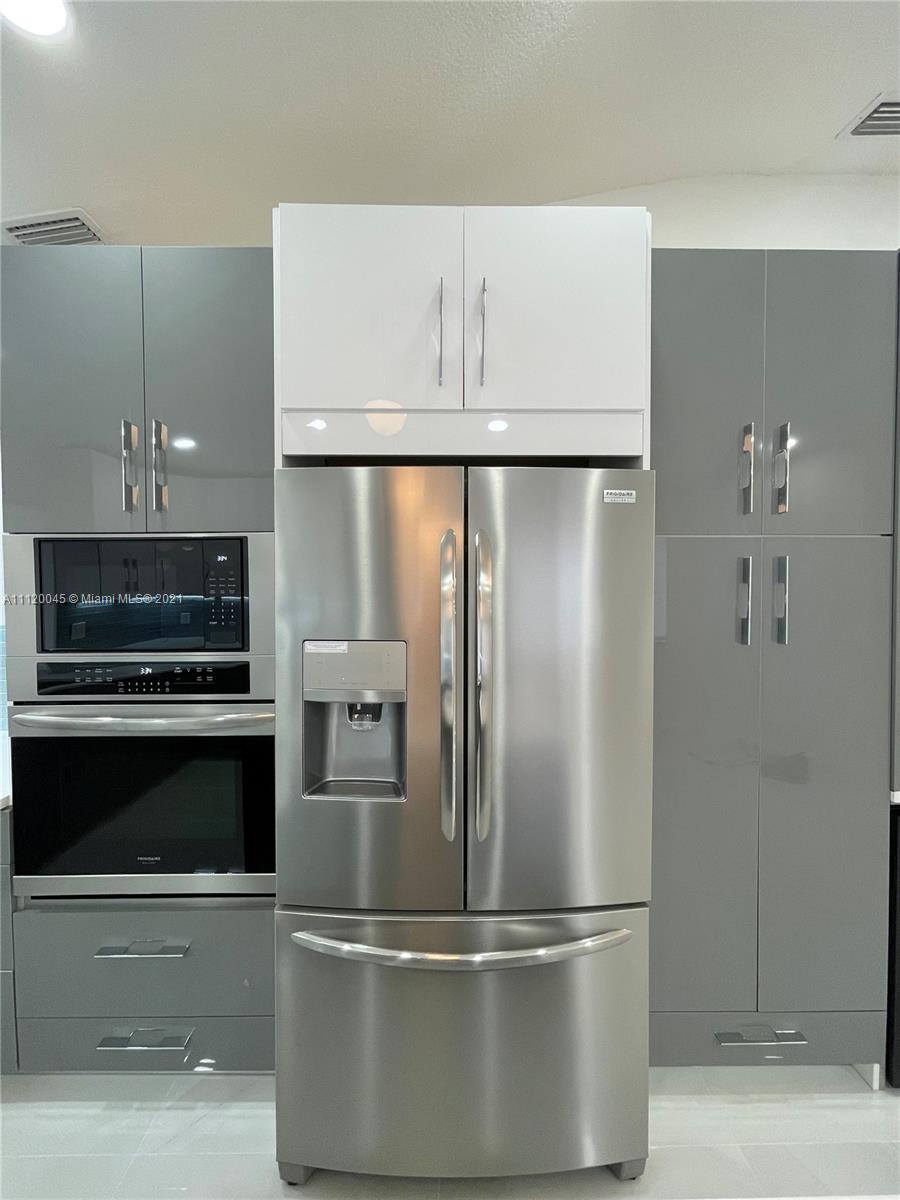 6726 Via Regina Boca Raton, FL 33433 - Photo 3 of 35 a metallic refrigerator freezer and a microwave in a kitchen