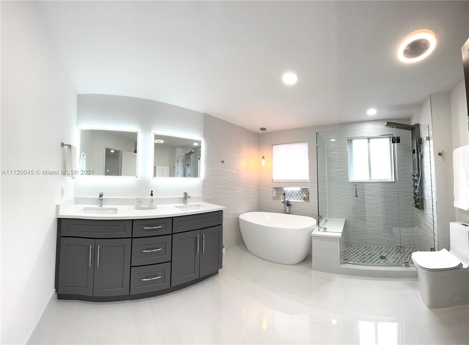 6726 Via Regina Boca Raton, FL 33433 - Photo 23 of 35 a spacious bathroom with a double vanity sink mirror and a bathtub