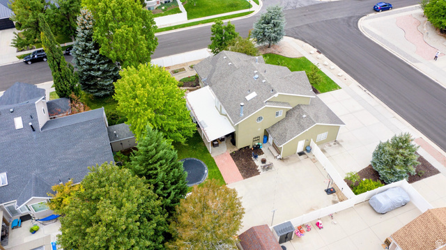 12169 Hidden Valley Road, Unit 44 Sandy, UT 84092 - Photo 43 of 49 Two-story residence with a light green exterior siding, gray shingle roofing, and multiple mature trees